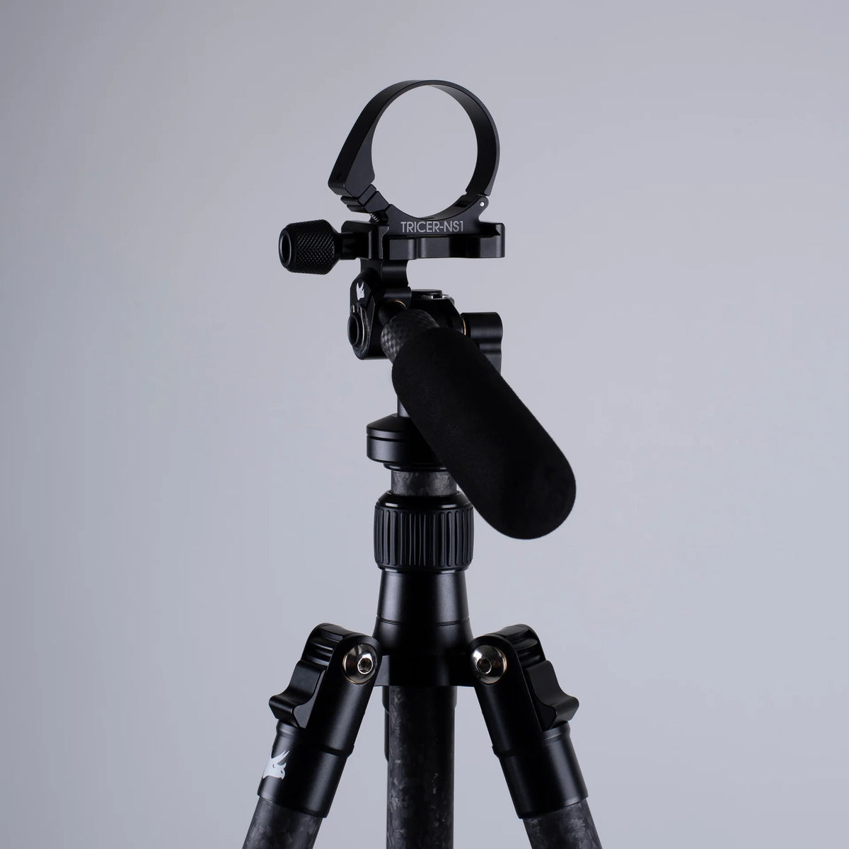 Black Arca-Swiss adapter on a tripod against a gray background