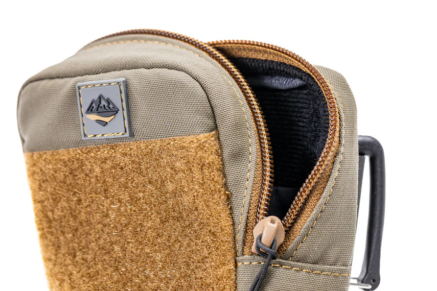 Close up of an open beige and brown pouch with zipper and visible brand logo on a white background