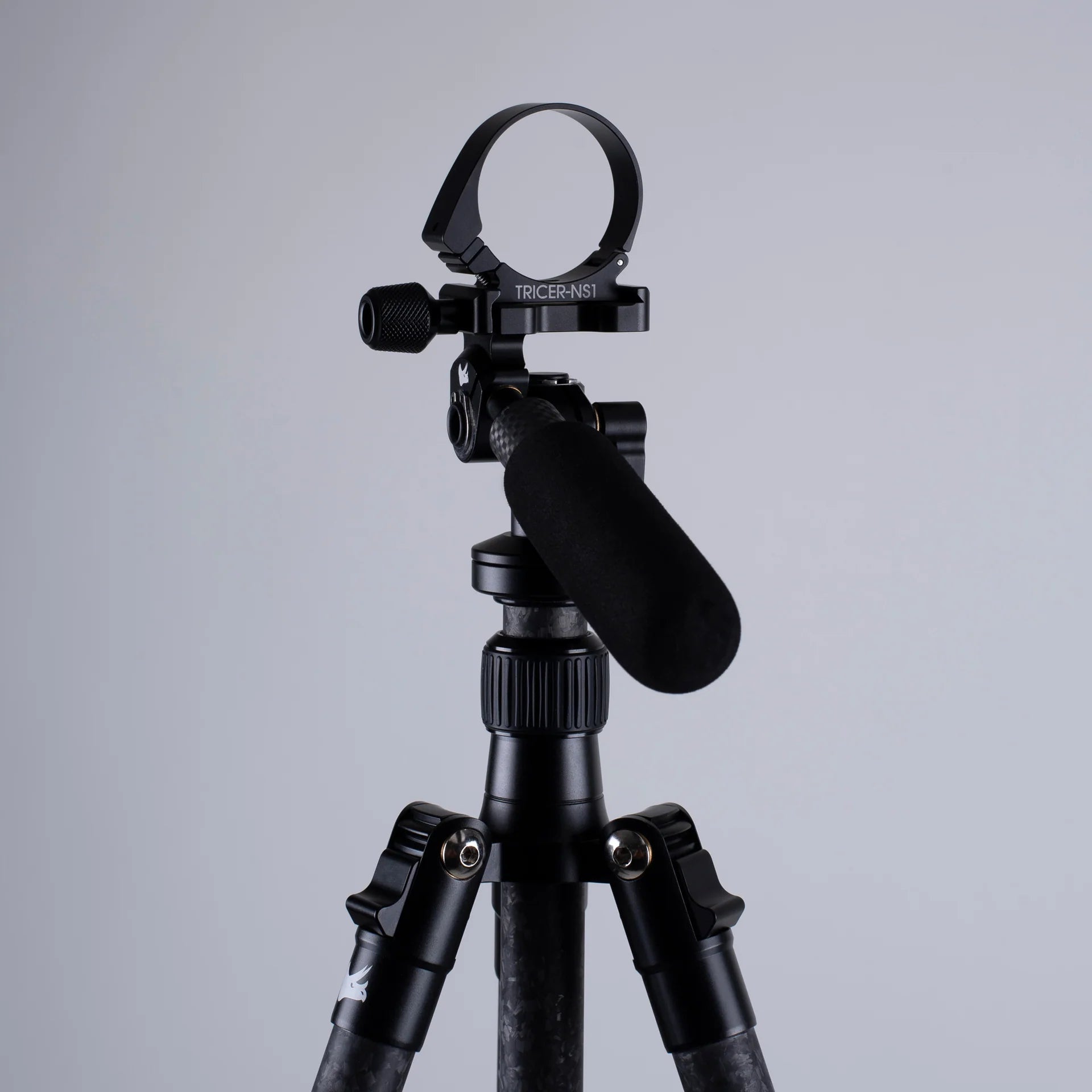Black Arca-Swiss adapter on a tripod against a gray background