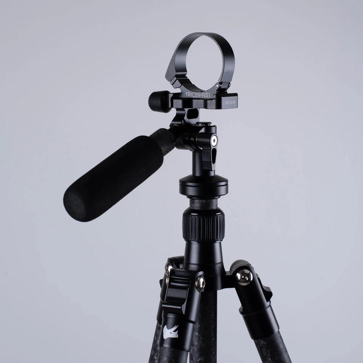 Black tripod with an Arca-Swiss adapter on a gray background